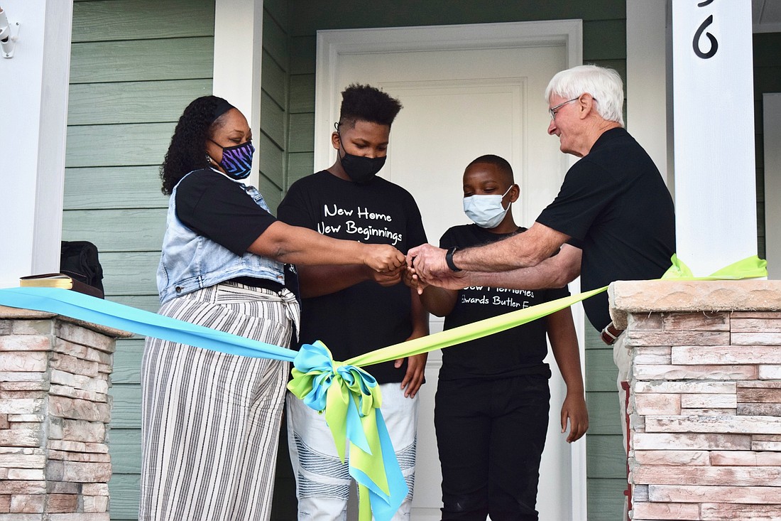 Antoinette Edwards and her sons, Josiah and Jylohn, accepted the keys to their new home from The Bond Foundationâ€™s Don Wingate.