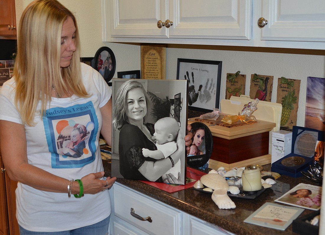 A small space next to the kitchen holds photos and mementos to remember the life of Connie Kochâ€™s daughter. She holds a painting created from a photo of Lyndsey Koch and her infant son.