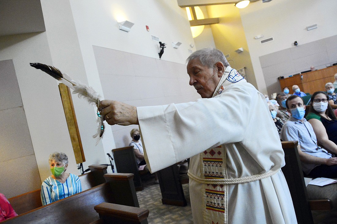 Retired United Church of Christ minister David Houseal waves a feather at stones placed in the sanctuary at Windermere Union Church during Native American Sunday.