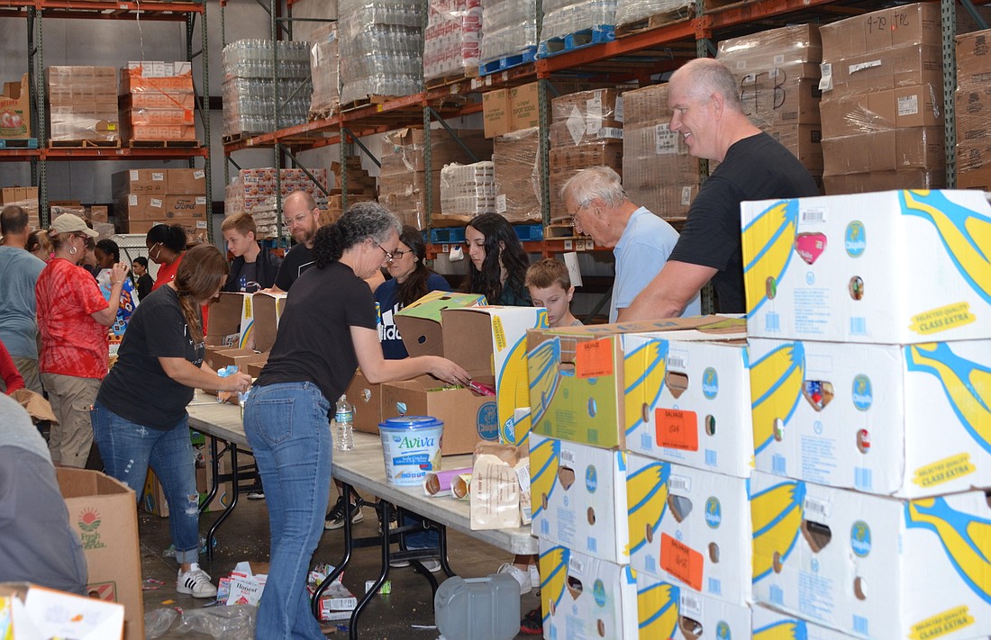 Highpoint Church volunteers formed an assembly line Saturday morning at Southeastern Food Bank to fill boxes with nonperishable food items to be distributed in the community Thanksgiving morning.