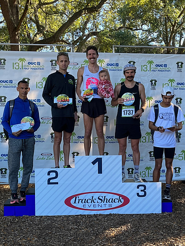 Joe Farrand took first place in the OUC Orlando Half-Marathon and celebrated with his daughter. The remainder of the Top 5 men were Aldren Biala, left, 4th; Kevin Collington, 2nd; Jean-Philippe Thibodeau, 3rd; Alexander Colon, 5th.