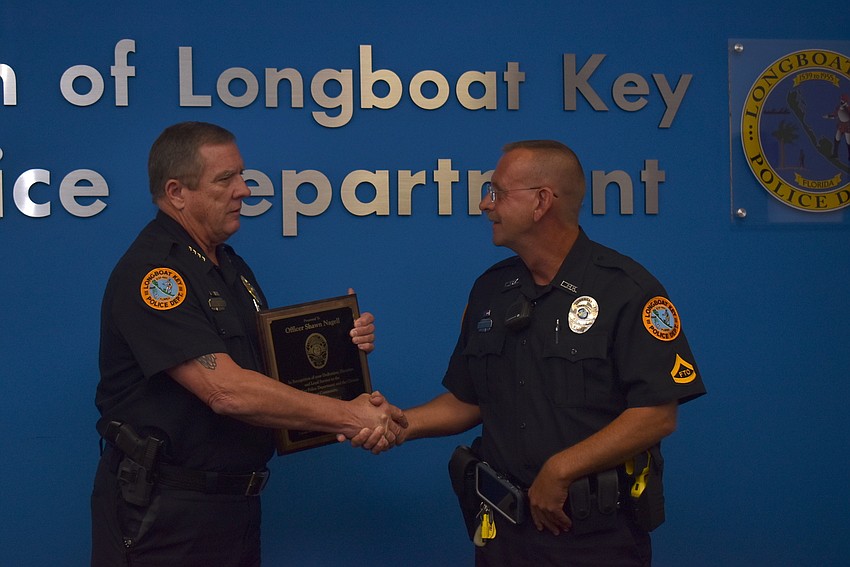 George Turner shakes hands with Shawn Nagell before giving him the plaque.