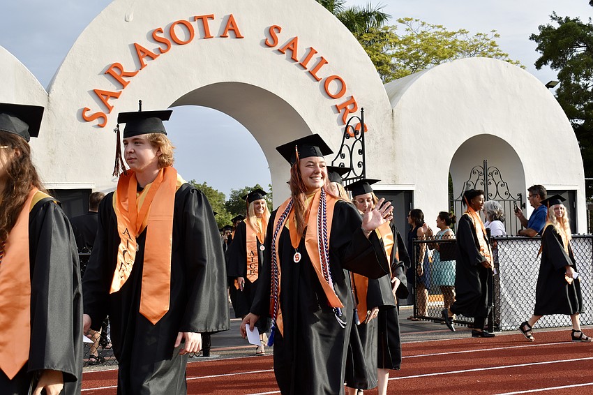 Two lines of seniors file through the gates of Cleland Stadium.