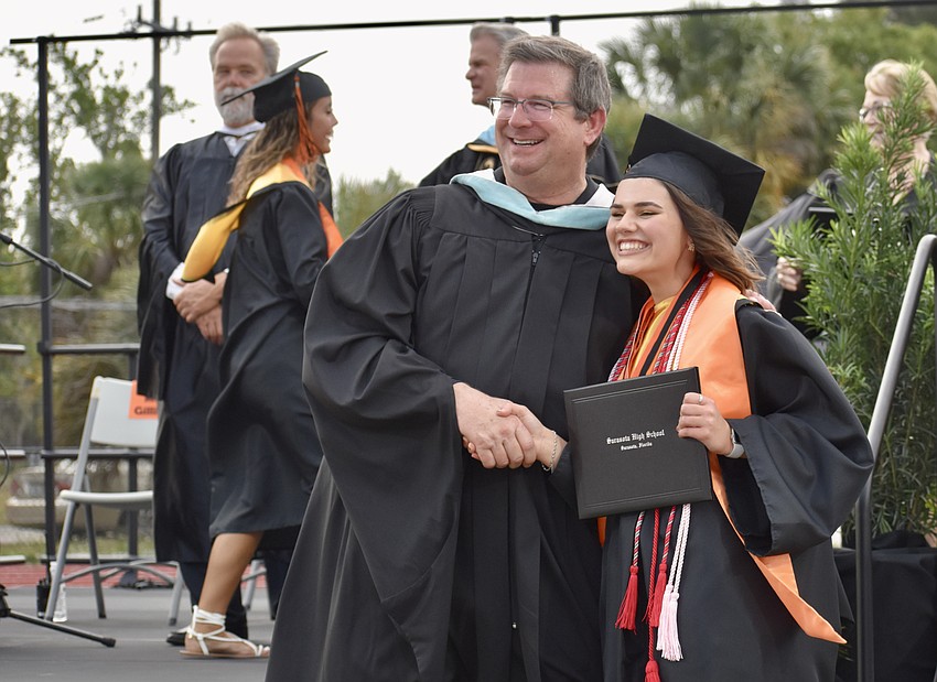 Principal David Jones shakes hands with Anya Studebaker.