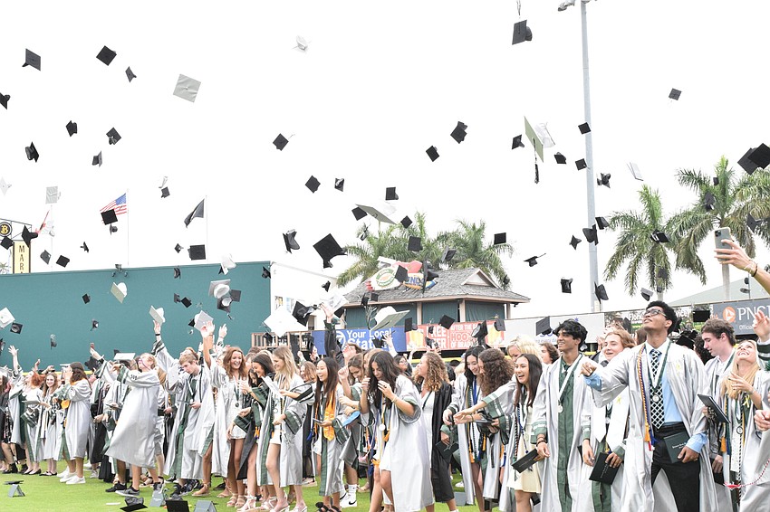Lakewood Ranch High graduates throw their caps in their air.