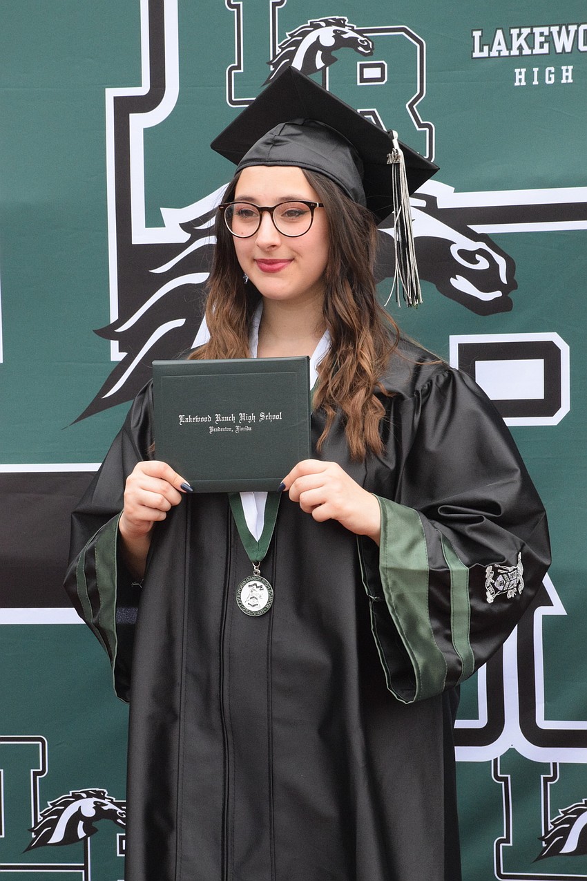 Hailey Nasce poses with her diploma, saying she is happy her high school career is over.