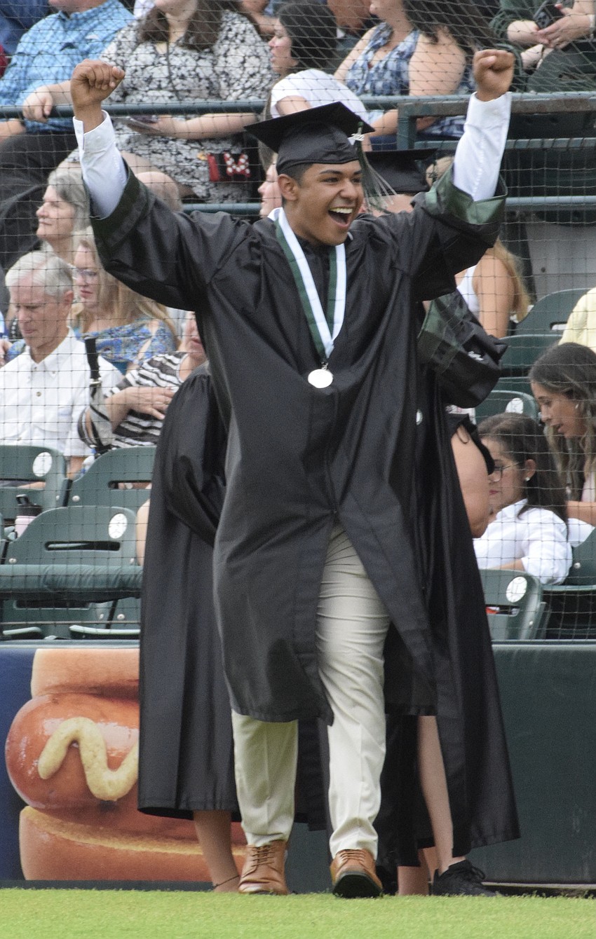 Jaykob Martinez celebrates on  his way to receiving his diploma.