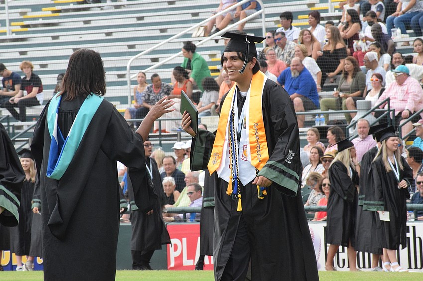 Assistant Principal Valencia Lowen hands a diploma to Matthew Boudreau.