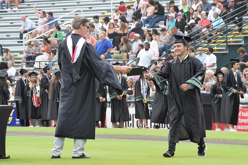Assistant Principal Mike Staker hands Pablo Moreno his diploma.
