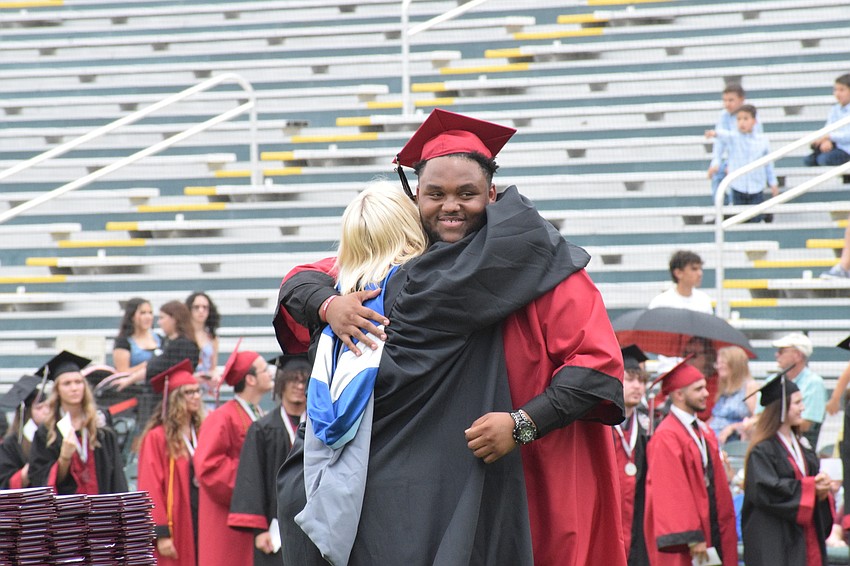 Assistant Principal Laura Gonzales hugs graduate Albert Dowling.