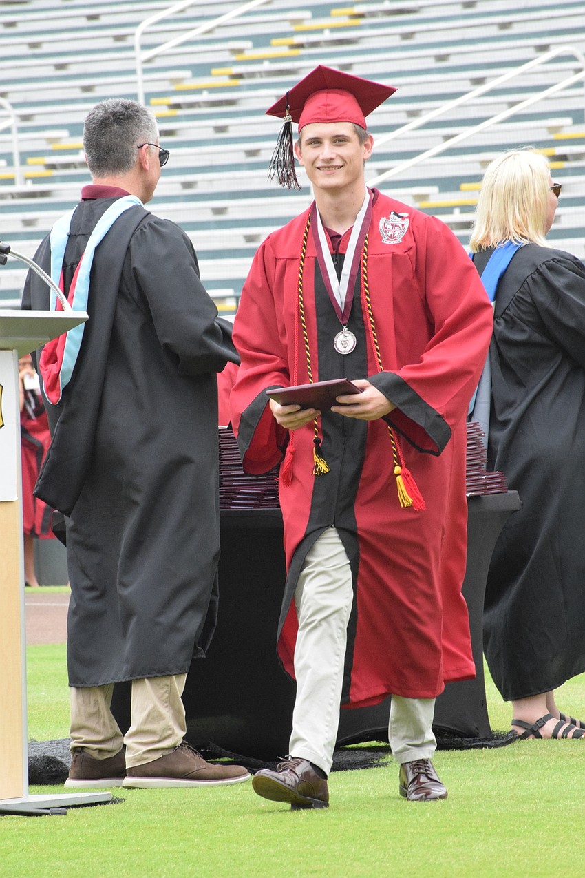 Brett Brustad makes his way across the field after accepting his diploma.