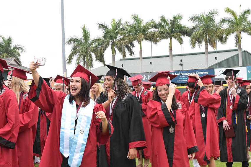 Amelia Linsberg takes a selfie with Farrah Brito and Melanie Ladd as they move their tassels from the right side of their caps to the left signifying they graduated from high school.