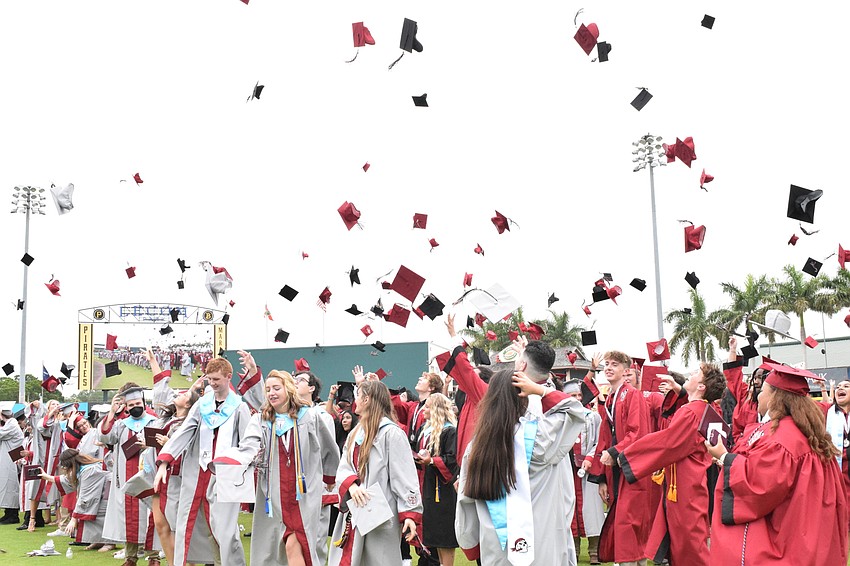 Braden River High School graduates throw their caps in the air.