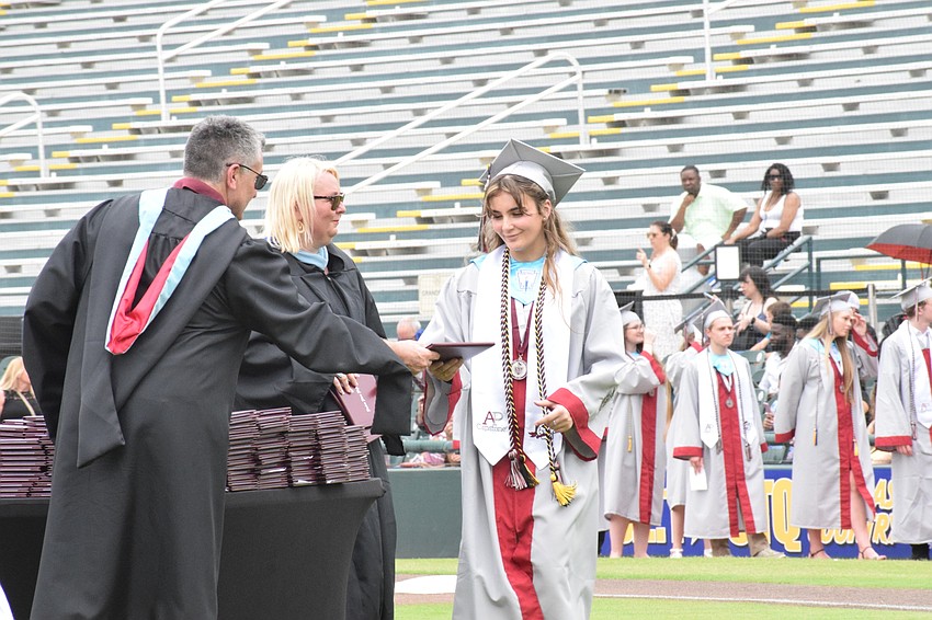 Assistant Principal Matthew Whelden hands Elayna Andrews her diploma.
