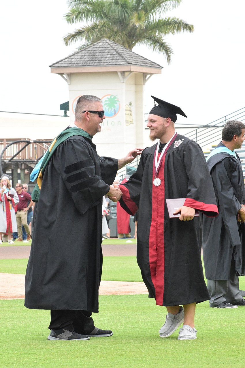 Principal Carl Auckerman congratulate Jacob Cook.