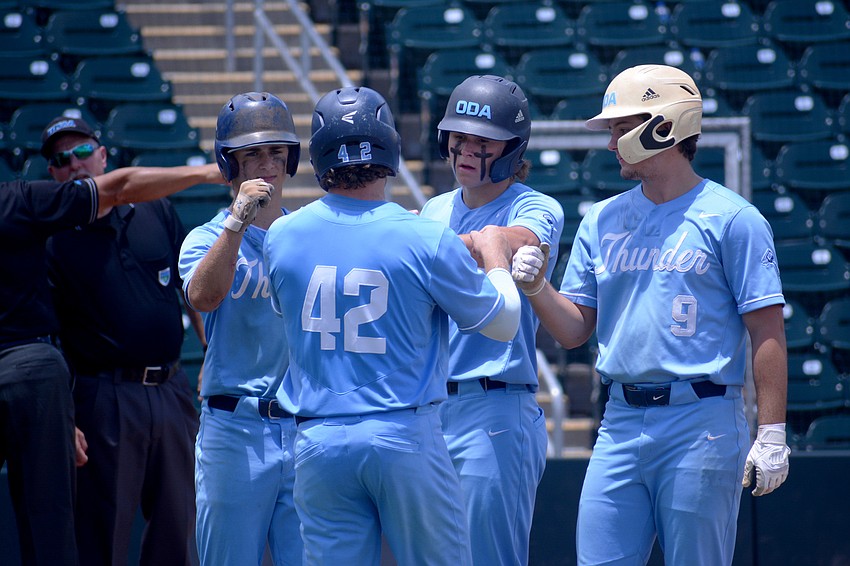 ODA senior Aidan Marino, junior Giovanni Giuliani and senior Logan Tribble fist bump junior Jack Hobson (42) pregame.