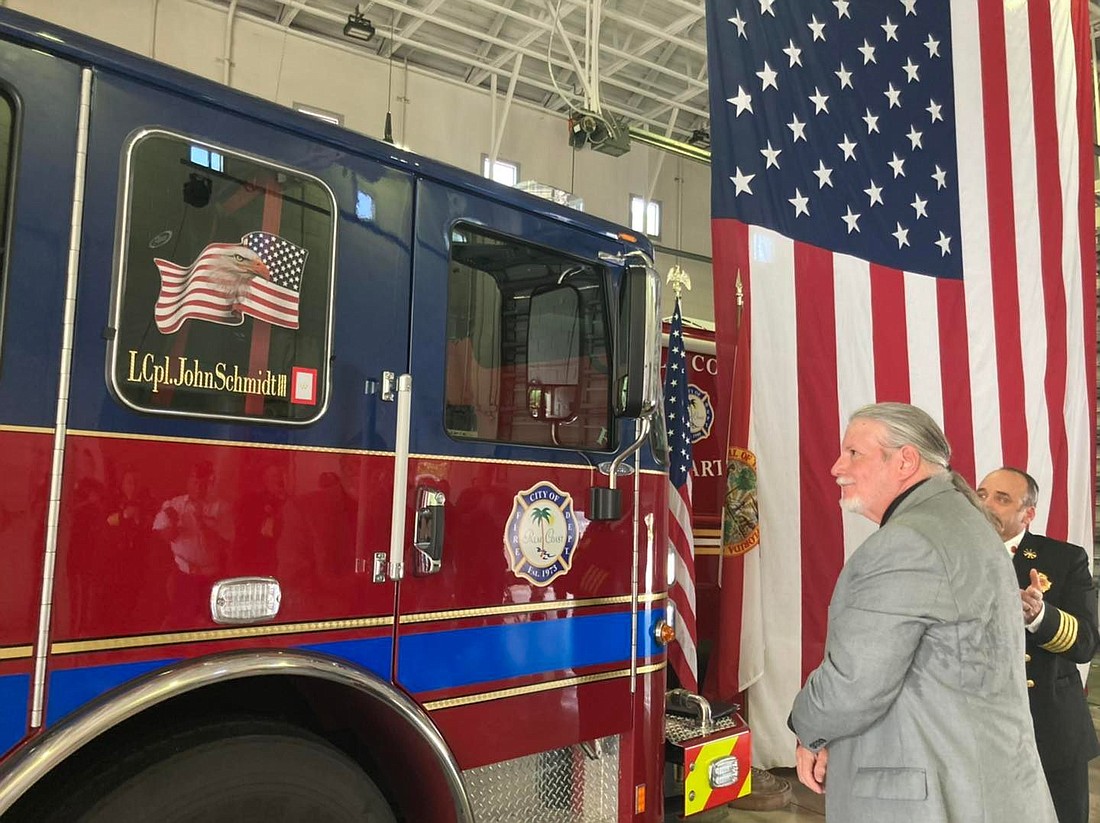John Schmidt Jr. unveils the name of his son, Marine Lance Cpl. John T. Schmidt III on Fire Engine 21. Courtesy photo