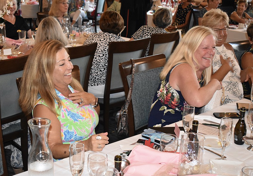 Jenny Sherr and Laurie Davis react as Davis wins a raffle prize, a set of Chesapeake candles.