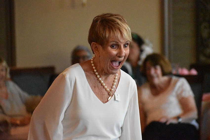 Anastasia Tess Magoulas reacts to the crowd as she shows off her necklace along with her outfit.