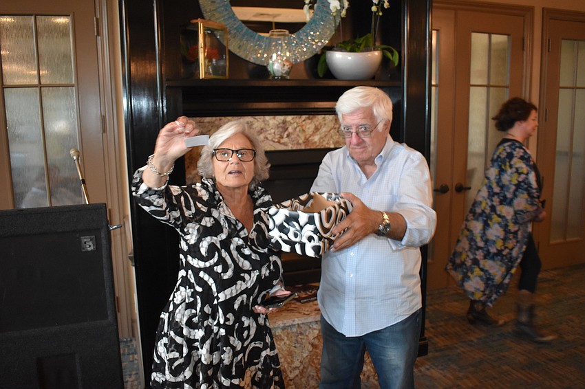 Event coordinator Eloise Eckler draws a winning raffle ticket.