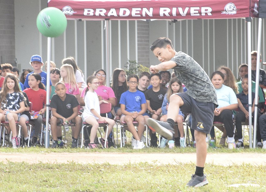 Fifth grader Jeremiah Pena launches the ball into the field.