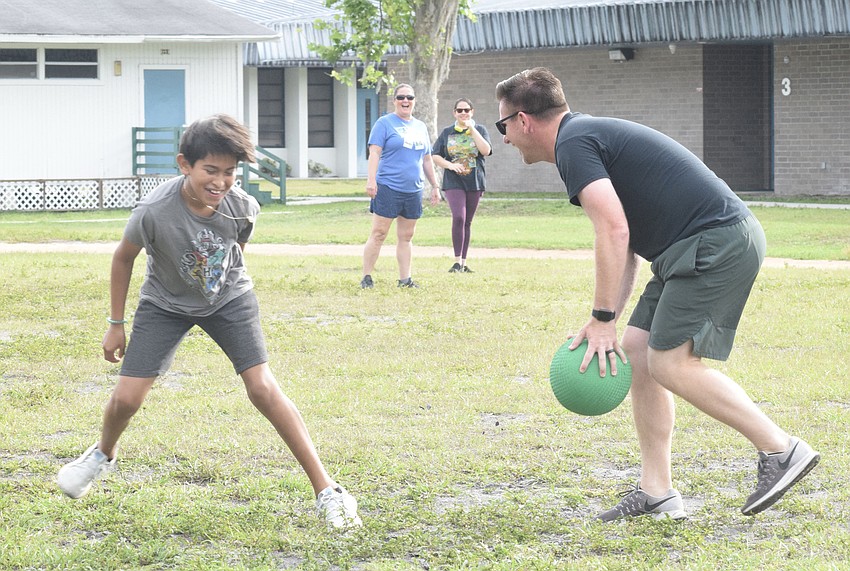 Fifth grader Levi Munoz tries his best to get around fourth grade teacher Matt McElhiney while trying to get to third base. McElhiney was able to get Munoz out before he reached the base.