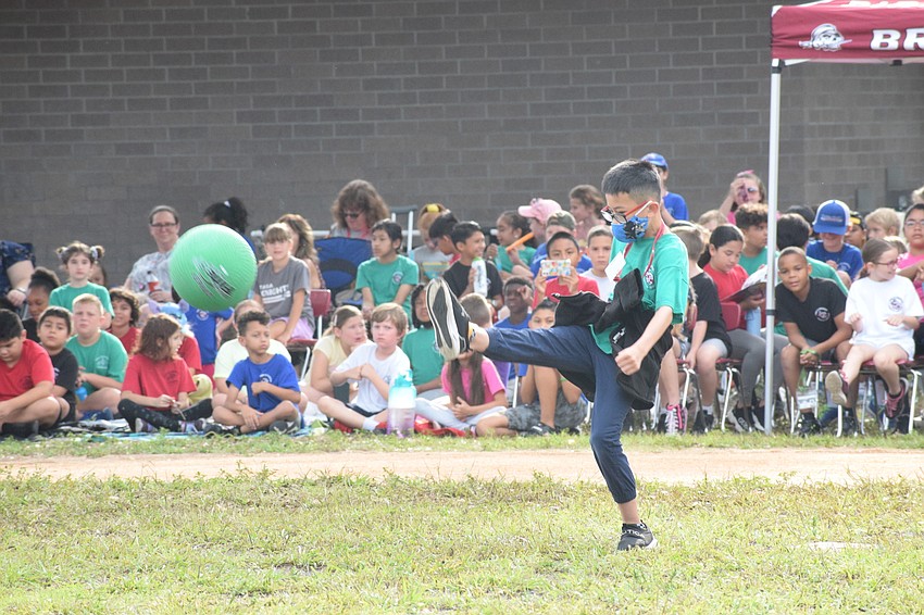 Fifth grader Jayden Bui puts all his strength into his kick. He safely made it to first base.