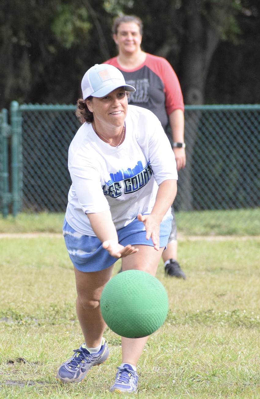 Third grade teacher Jeanne Rogers plays pitcher in the game.