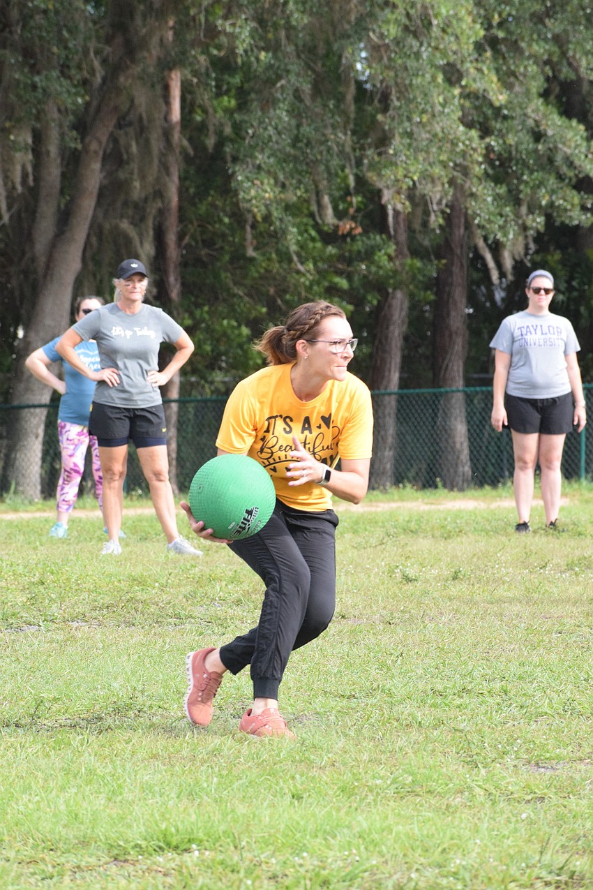 Principal Laura Campbell catches the ball before throwing it to first place in hopes of getting a fifth grader out.