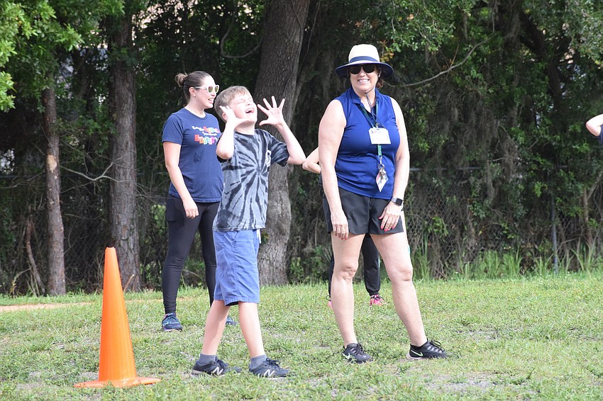 Fifth grader Sam Weathers cheers for his teammates while physical education teacher Linda Haluska waits for the ball to be in play.