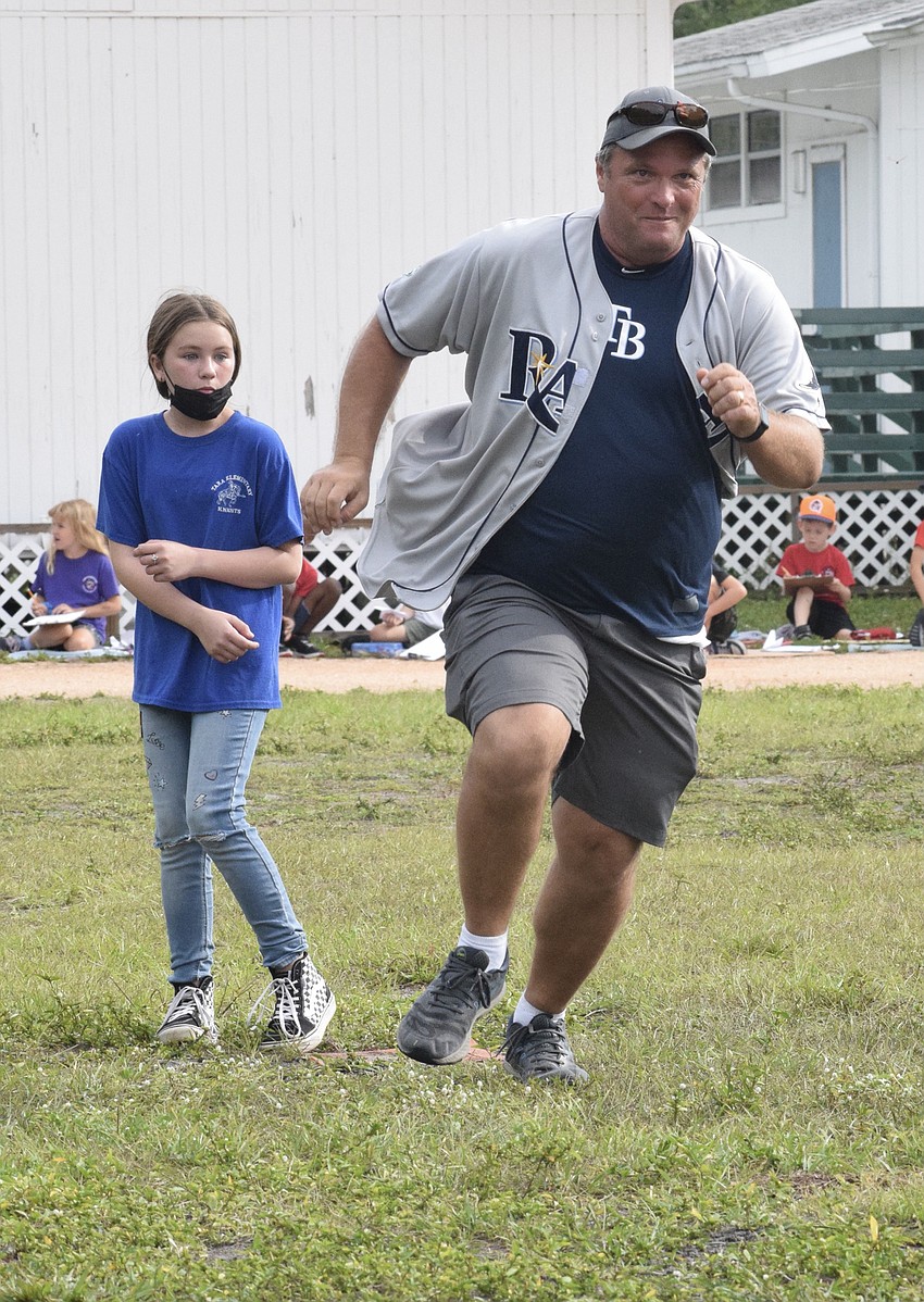 Third grade teacher Chuck Rogalla makes his way past second for a home run for the staff. He was able to get two runs for the staff and was greeted with high fives at home plate.