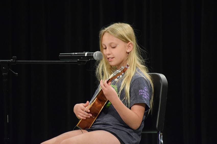 Fifth grader Emily Harris plays ukulele while singing Bruno Mars' 