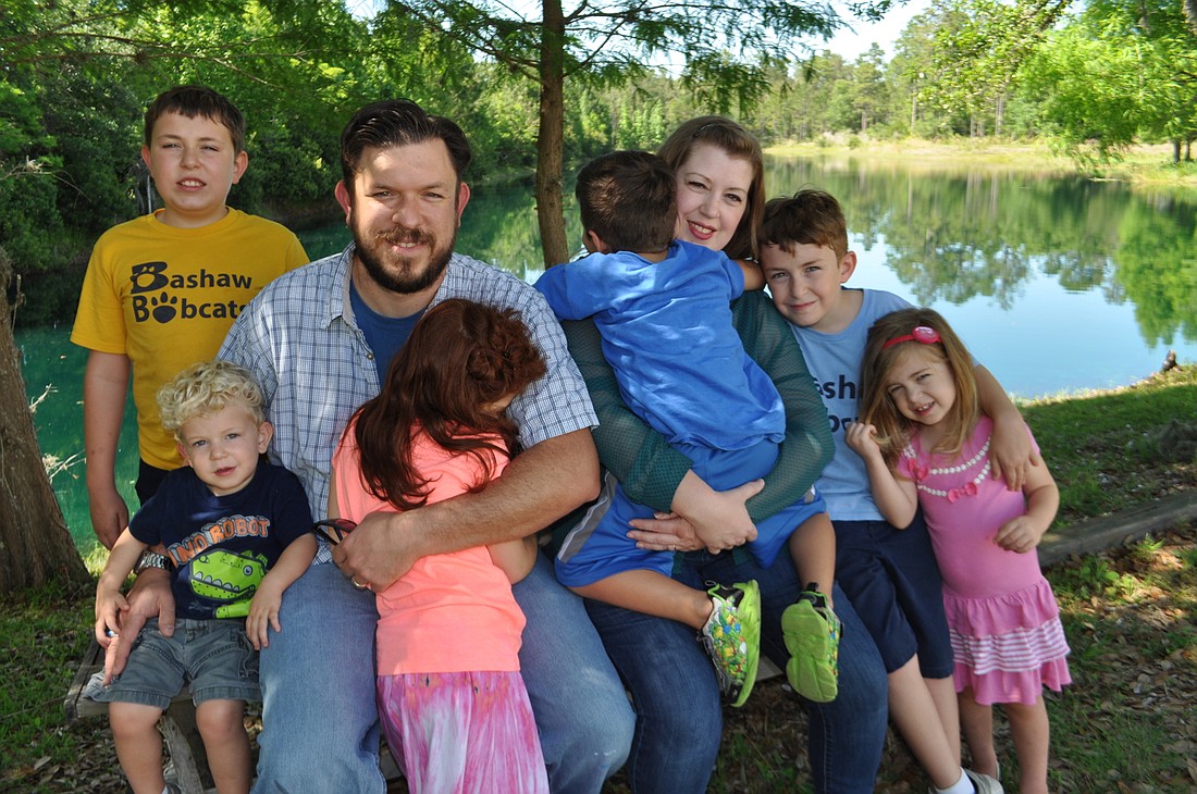Tom and Holly McAndrew gather with their children Thomas, 11, Merritt, 2, two foster children, center, Owen, 9, and Scarlette, 3. Photo by Pam Eubanks