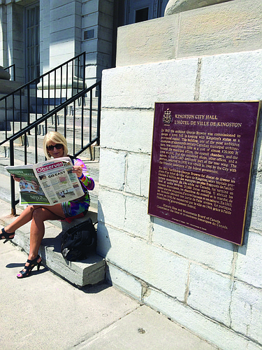 NORTHERN EXPOSURE. Denise LaViolette reads her Sarasota Observer in front of Kingston City Hall in Ontario, Canada.