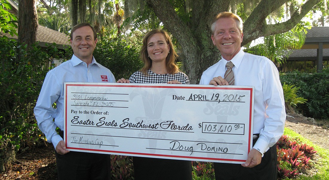 Tom Waters, president and CEO of Easter Seals, Rose-Anne Frano, board chairwoman of Easter Seals, and Doug Domino, general manager of Meadows Country Club, show off the the monetary contribution.