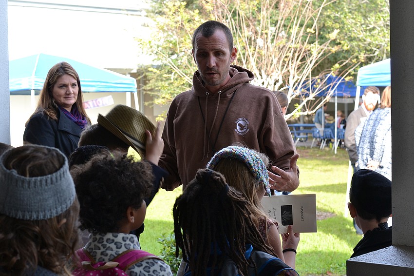 Second grade teacher James Anderson gives students instruction as they arrive at Ellis Island.