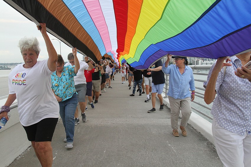 JUNE: Project PRIDE SRQ staff and supporters walk the flag up the bridge.