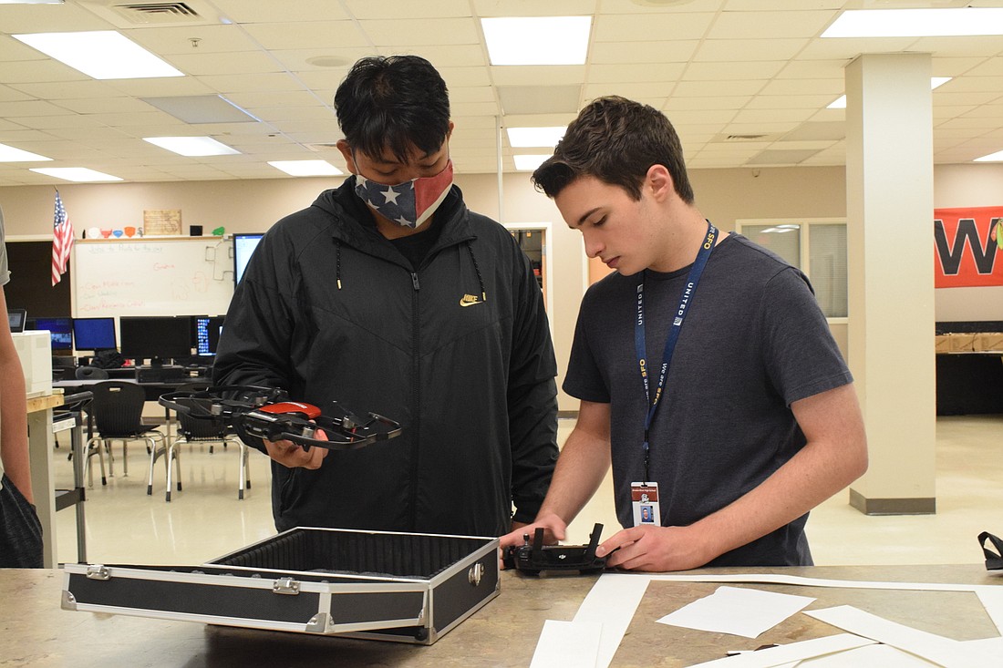 Freshman Allan Tran and junior Dylan Jackson set up a drone. They passed a safety course that brings them one step closer to driving drones commercially.