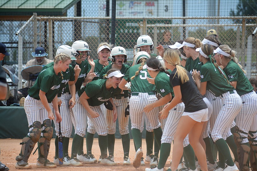 The Mustangs greet senior Ella Coiner (5) at home plate following Coiner's grand slam in the team's 11-3 win over Western High.