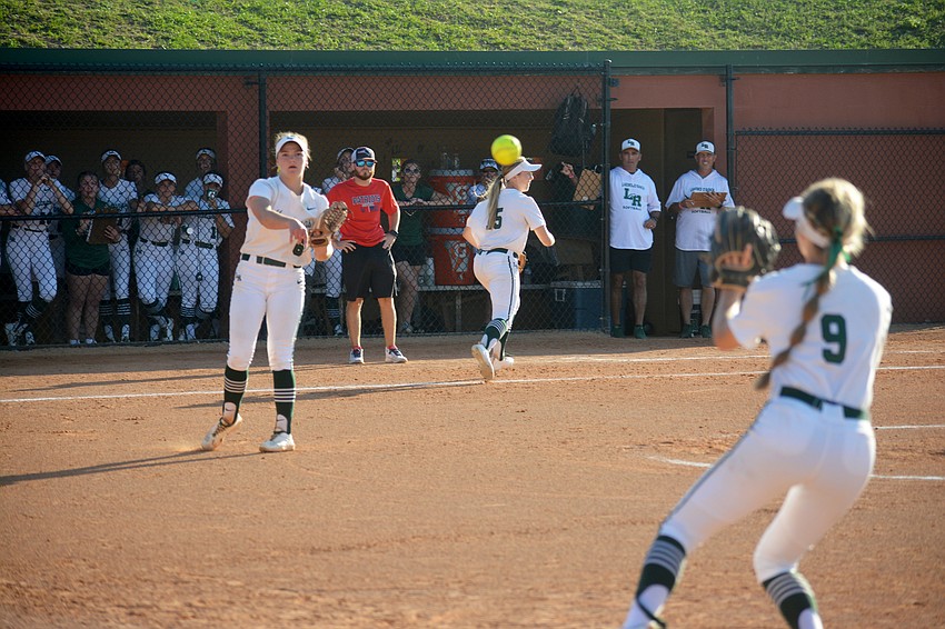 Lakewood Ranch sophomore Ella Dodge tosses a ball to senior Kelsey Vogel for an out at first base against Lake Brantley High.