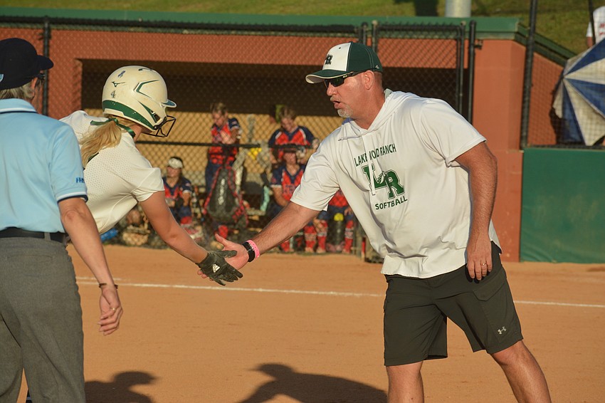 Lakewood Ranch High senior Grace Hogie and Head Coach T.J. Goelz high-five after Hogie tripled against Lake Brantley High.