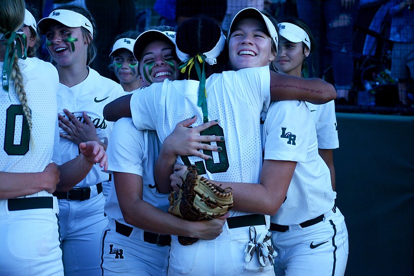 Lakewood Ranch senior Taylor Shepherd and junior Cassidy McLellan hug senior Sydney McCray (20) after the Mustangs defeated Lake Brantley High 8-2 to win the Class 7A state championship.