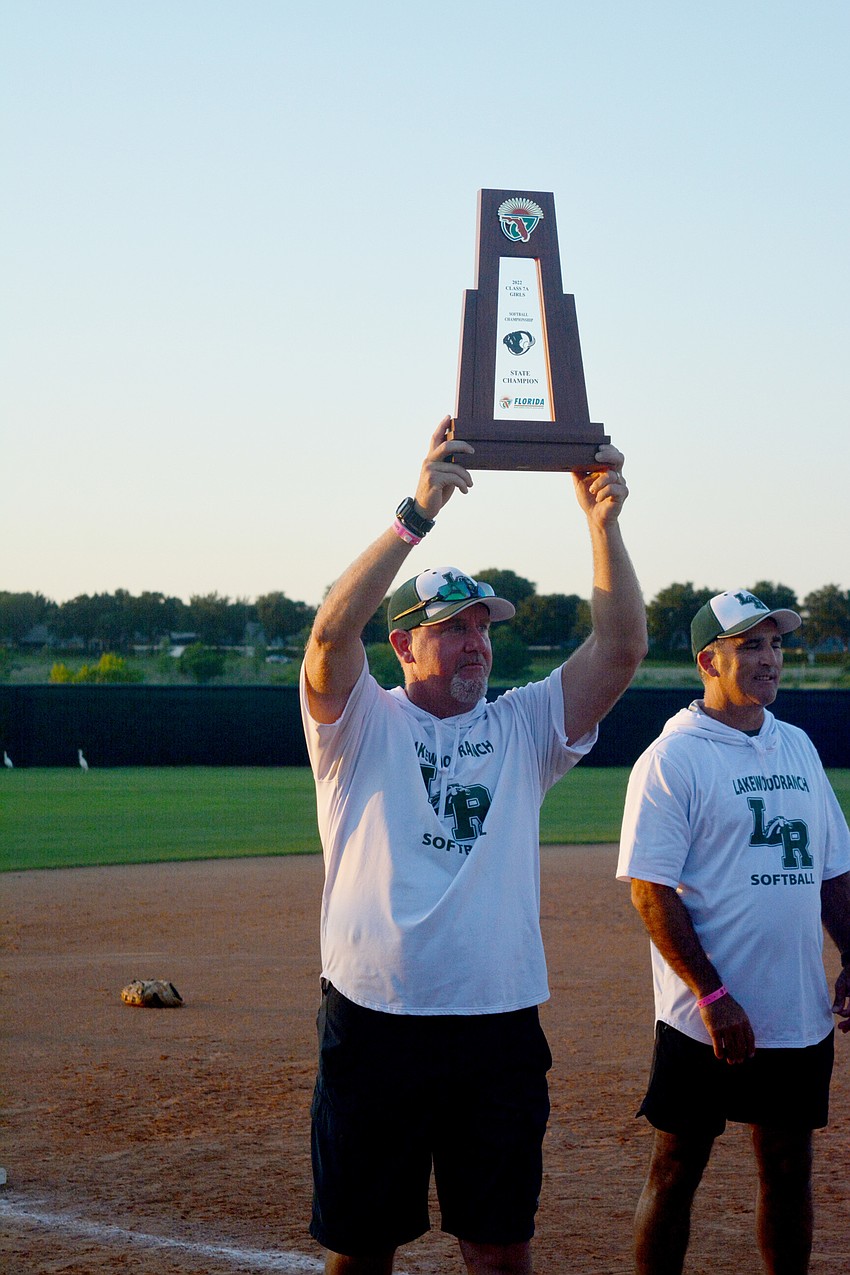 Lakewood Ranch High softball Head Coach T.J. Goelz holds up the team's Class 7A state championship trophy.