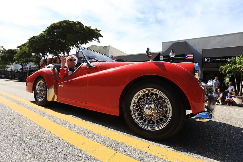 Several parade participants ride in classic cars.