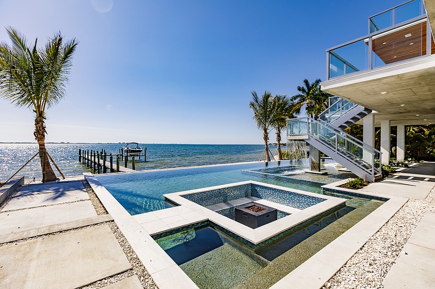 The backyard, overlooking Sarasota Bay and Longboat Key beyond, features as its centerpiece a resort-style swimming pool, a spa, waterfall, in-pool bar and sun lounges and a sunshelf.
