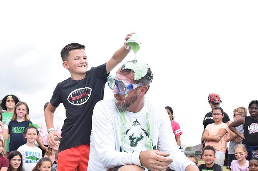 Third grader Brandt Rumbaugh dumps a cup of slime onto Principal Todd Richardson.