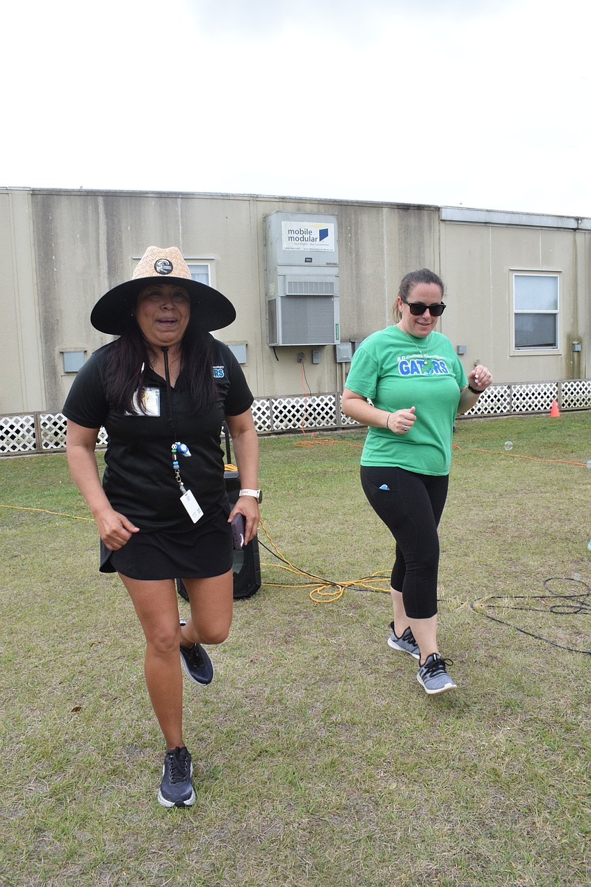 Juana Dreier, a physical education coach, and Brittani Barnes, a third grade teacher, dance together.