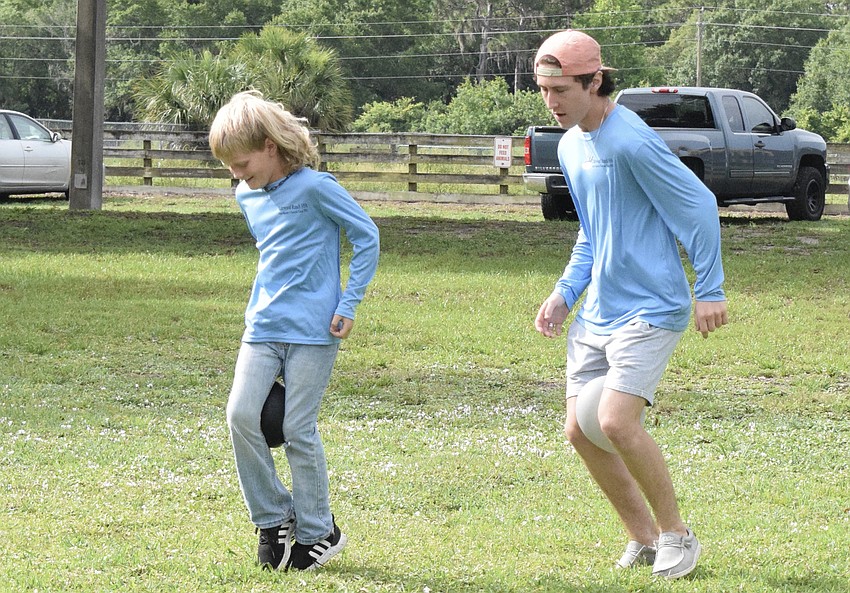 Brock Sampson, a rising fifth grader, and Max Mangus, who just graduated from Lakewood Ranch High, try to waddle while holding balloons between their legs. Mangus says it has been fun getting to know the campers.