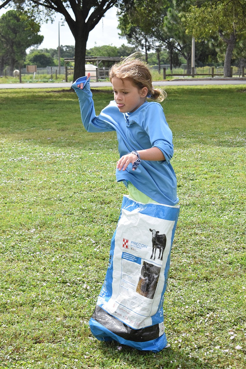 Ryleigh Fangue, a rising third grader, hops as fast as she can in the feed sack race. Fangue has enjoyed learning about animals and plants and participating in the various activities throughout the week.