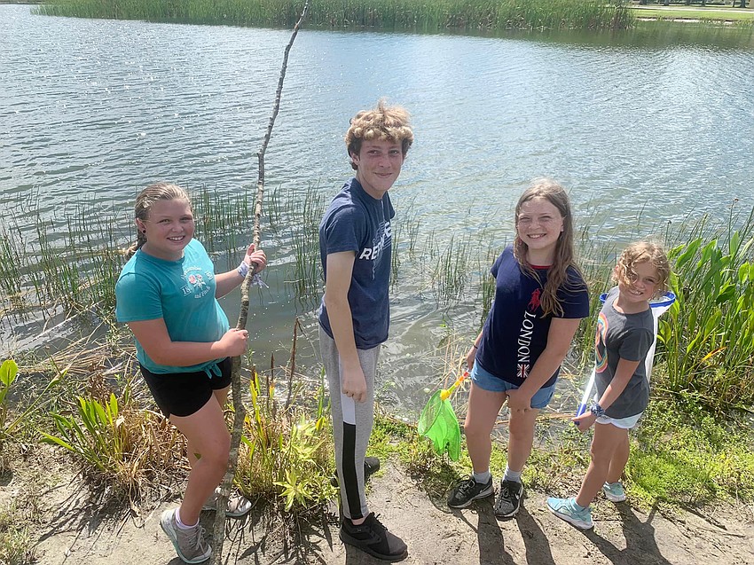 Nahla Vlasak, a rising fifth grader, Bryon Simon, a rising sophomore, Kinley Kirker, a rising sixth grader, and Ryleigh Fangue, a rising third grader, use sticks and nets to fish rather than fishing rods. Courtesy photo.